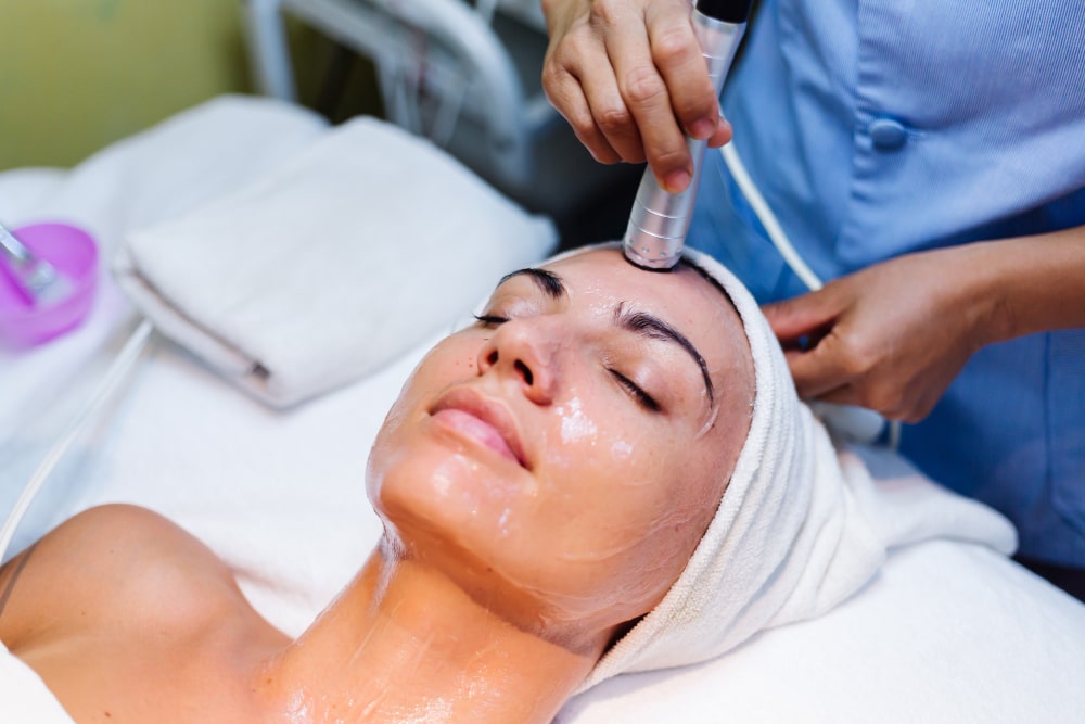young-woman-lying-on-cosmetologist-s-table-during-rejuvenation-procedure-min